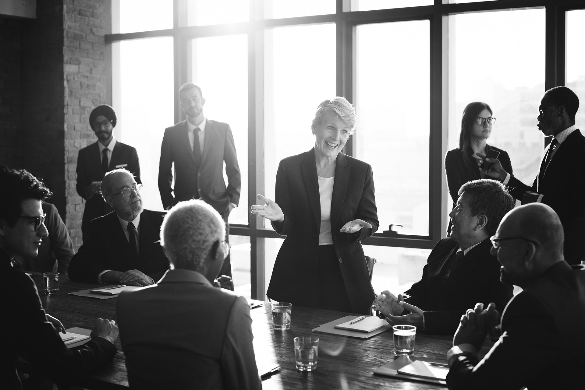 Meeting Leader group participating board room. Speaker and Listener near windows.